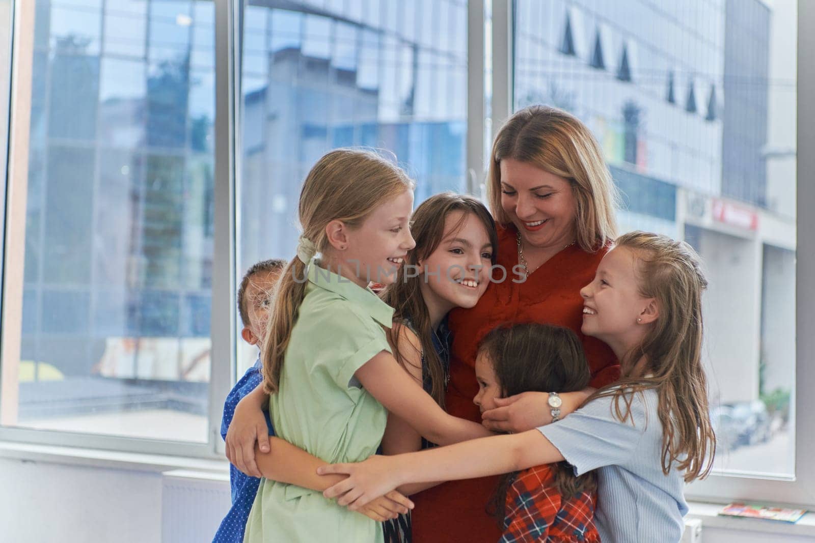 A child hugging a teacher in a modern kindergarten. High quality photo