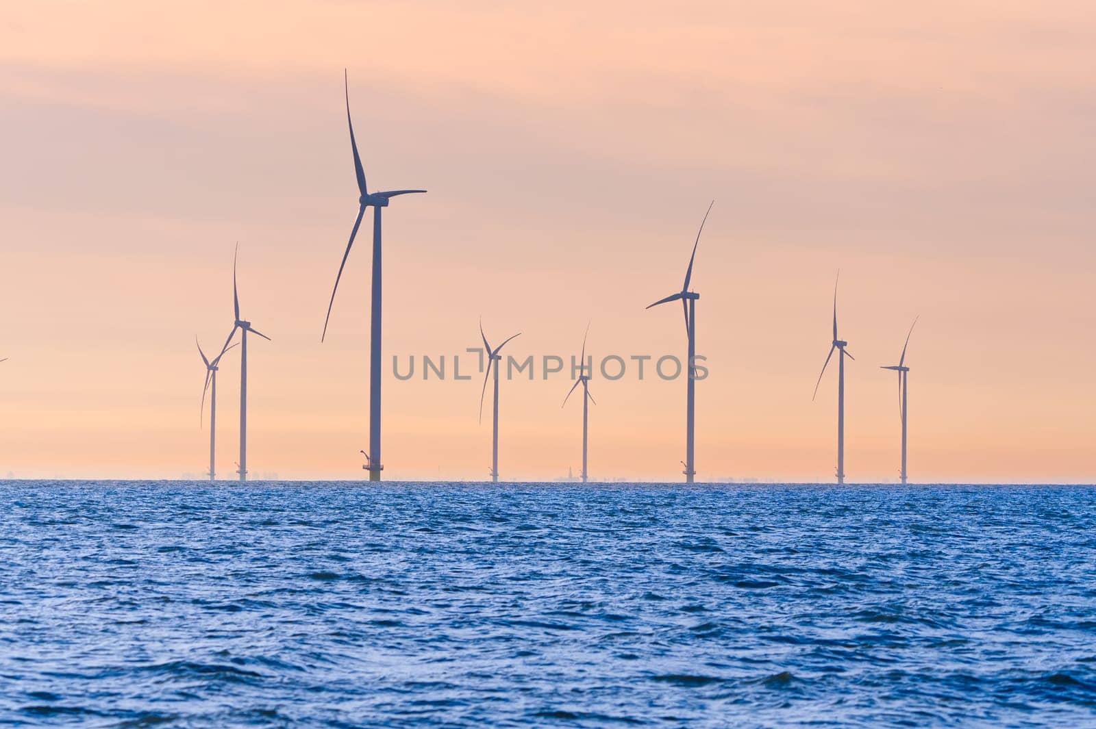 Offshore Windmill farm. windmills isolated at sea on a beautiful bright day Netherlands by PhotoTime