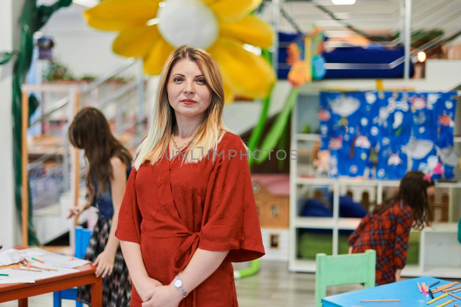 Portrait of a teacher in a preschool institution, in the background of the classrooms by dotshock