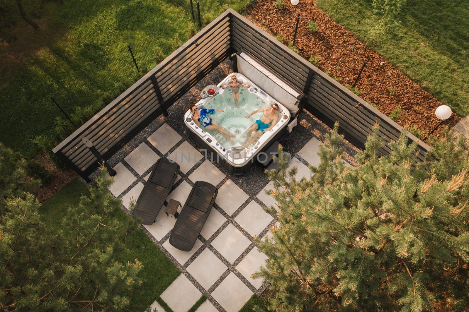 Top view of a family relaxing in an outdoor hot tub in summer.