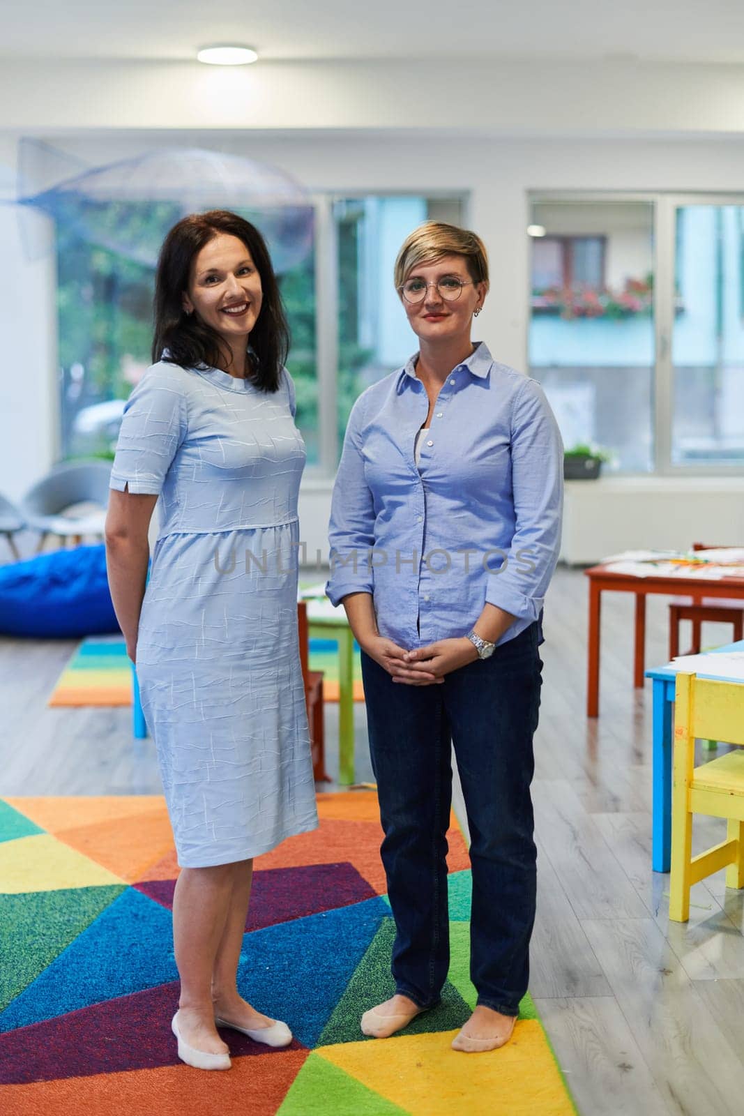 Portrait of a two teacher in a preschool institution, in the background of the classrooms.