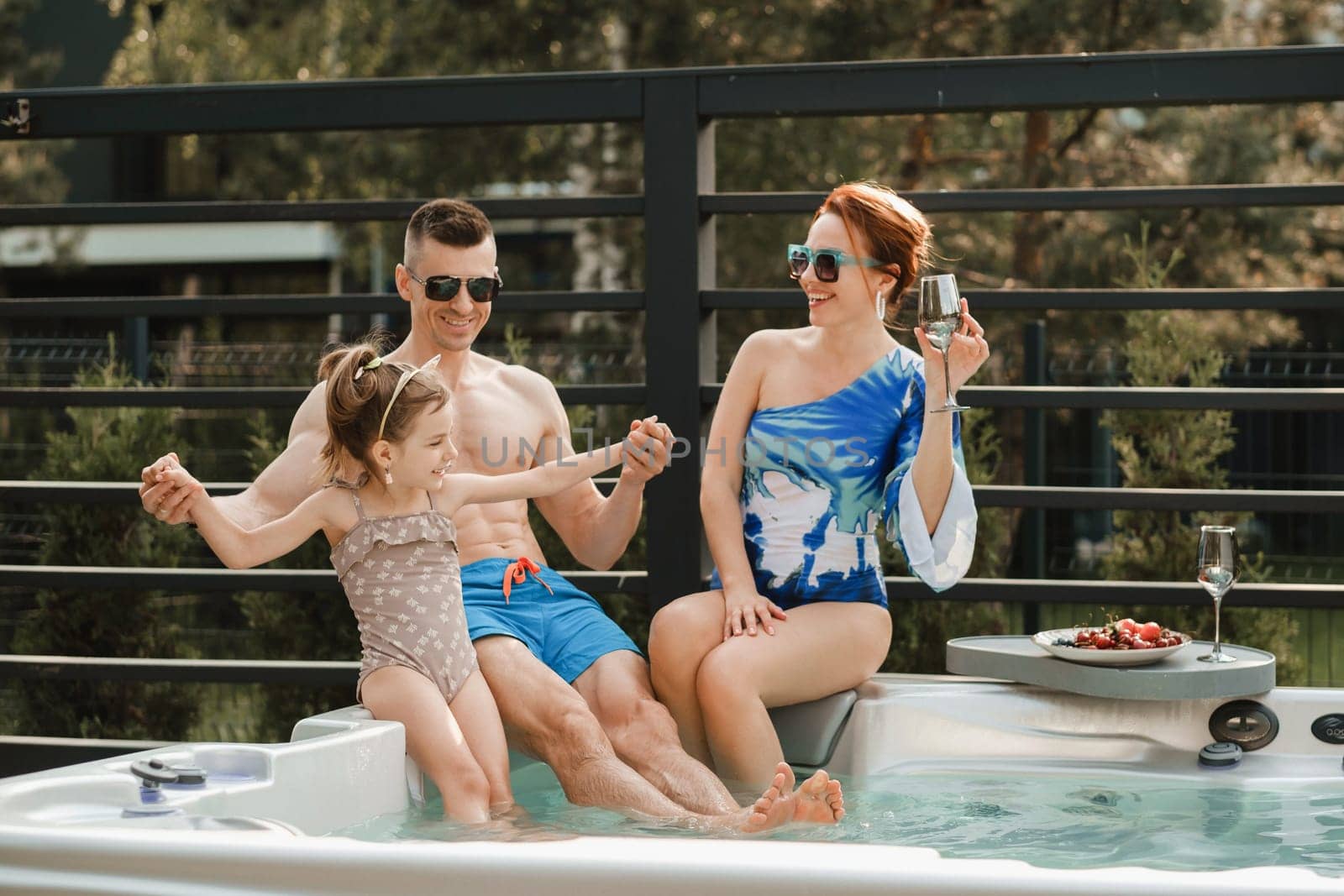 In summer, the family rests in the outdoor hot tub.