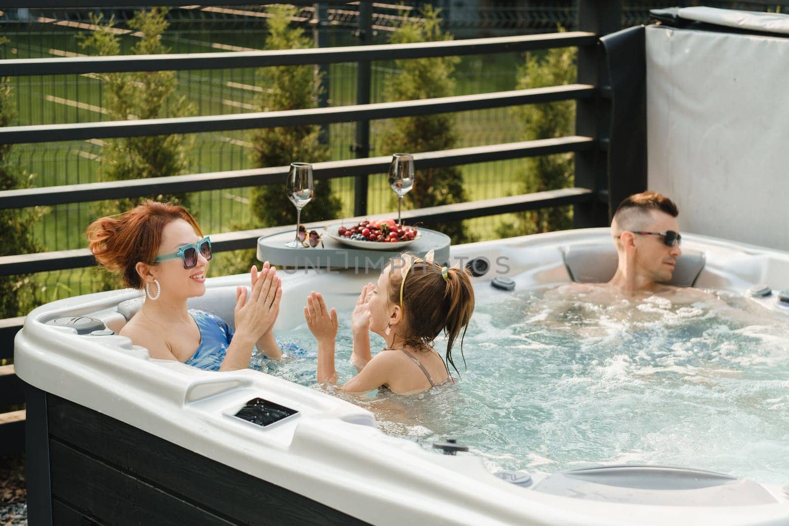 In summer, the family rests in the outdoor hot tub.