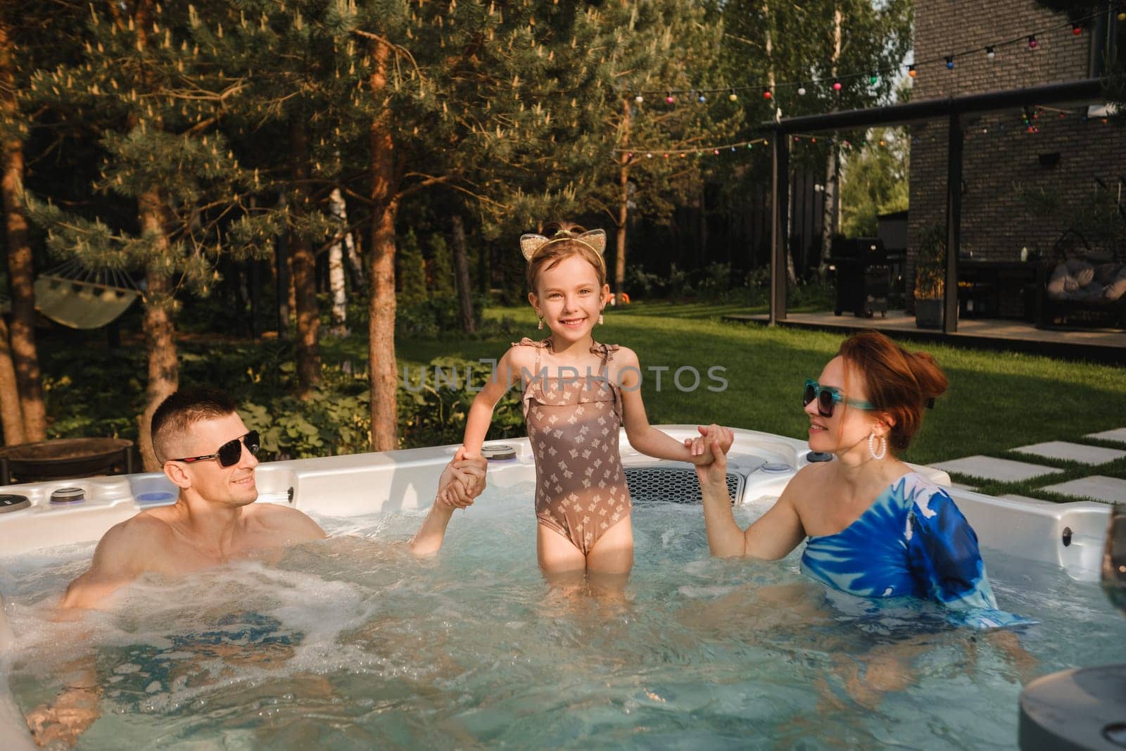 In summer, the family rests in the outdoor hot tub.