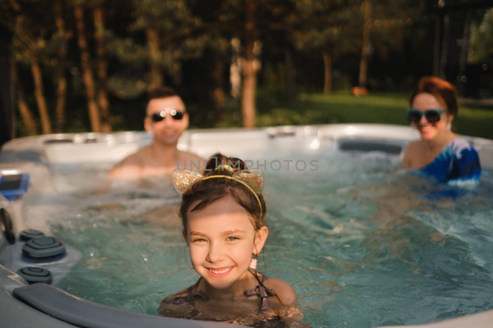 In summer, the family rests in the outdoor hot tub.