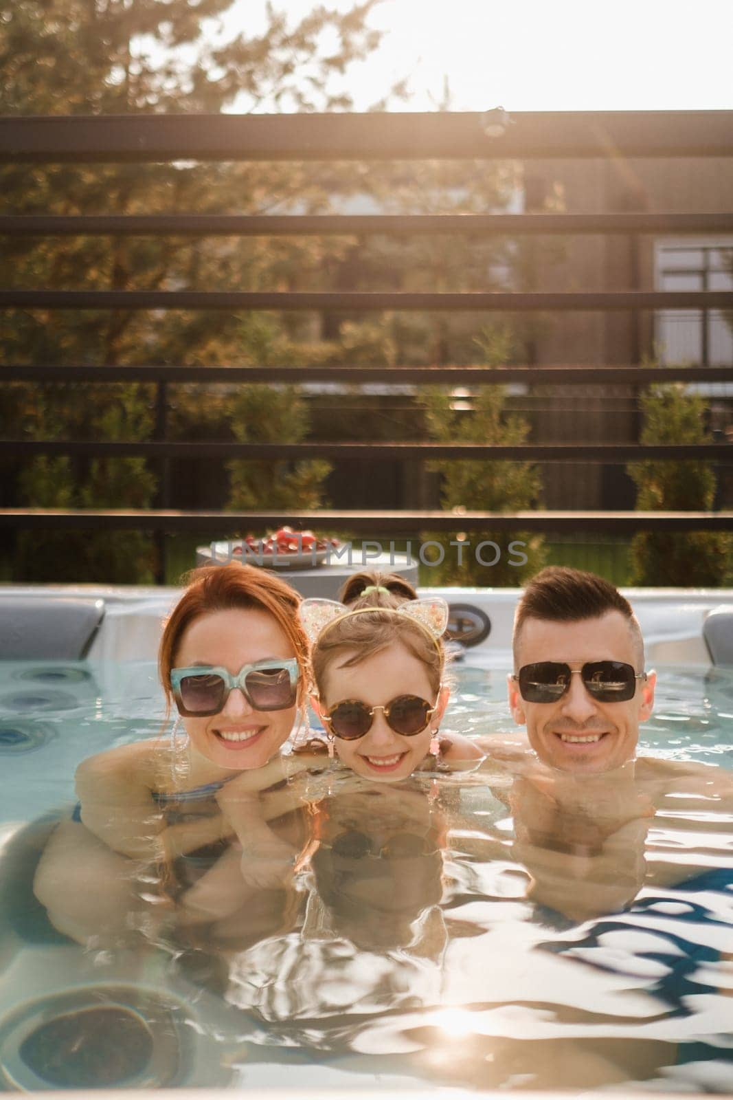 In summer, the family rests in the outdoor hot tub.