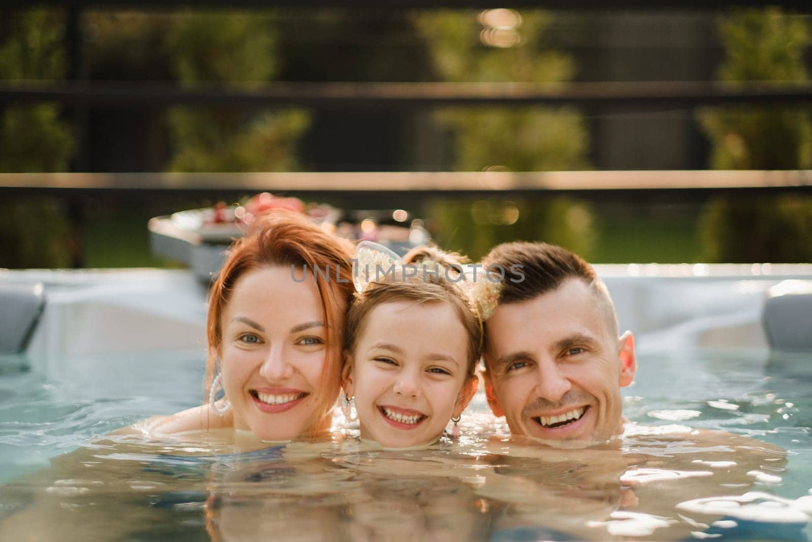 In summer, the family rests in the outdoor hot tub.