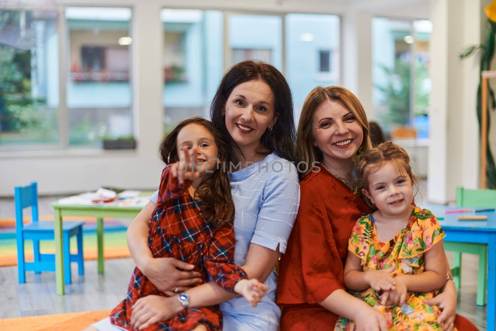 A child hugging a teacher in a modern kindergarten. High quality photo