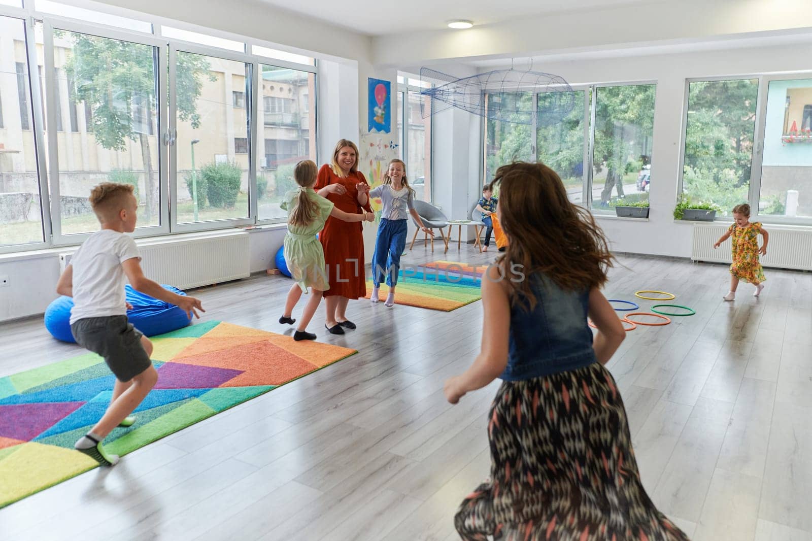 A child hugging a teacher in a modern kindergarten by dotshock