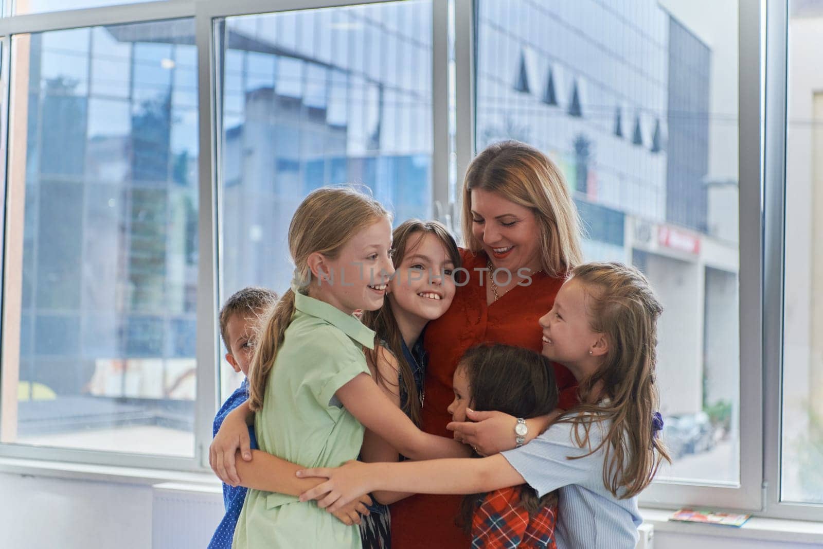 A child hugging a teacher in a modern kindergarten. High quality photo