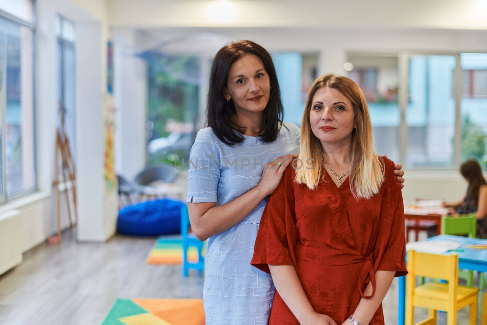 Portrait of a two teacher in a preschool institution, in the background of the classrooms.