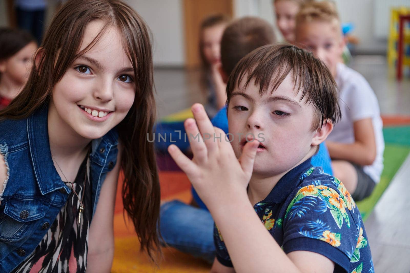 A girl and a boy with Down's syndrome in each other's arms spend time together in a preschool institution by dotshock