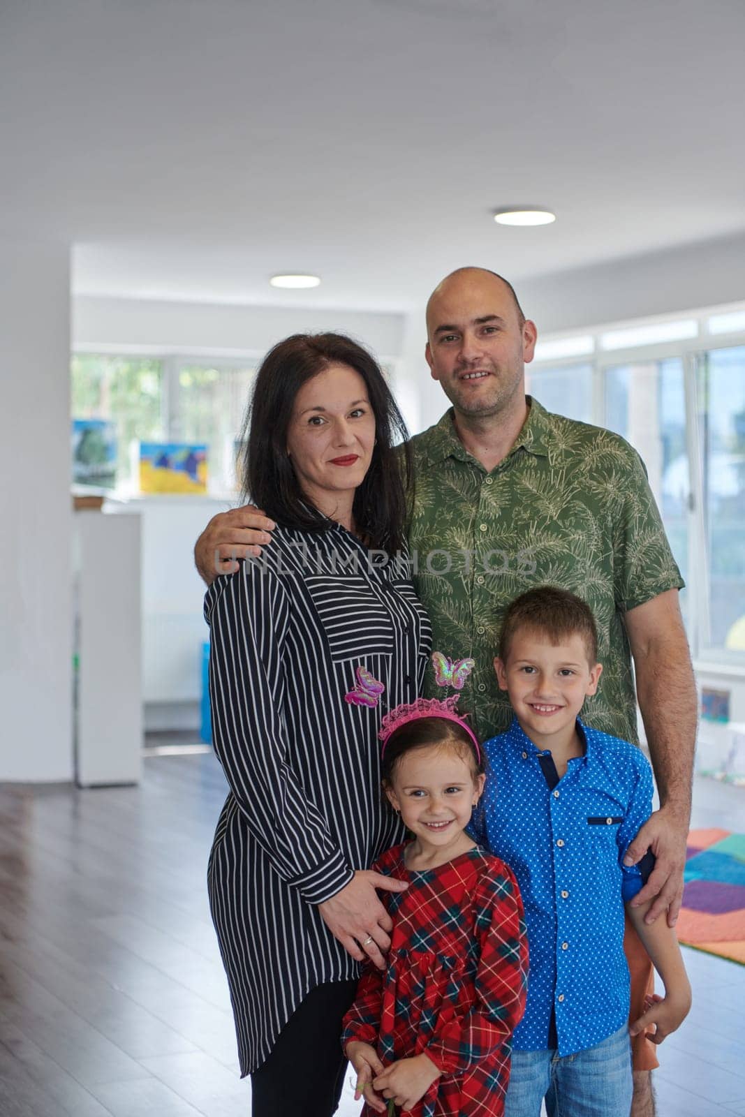 Portrait of a happy family. Photo of parents with children in a modern preschool classroom. Selective focus .