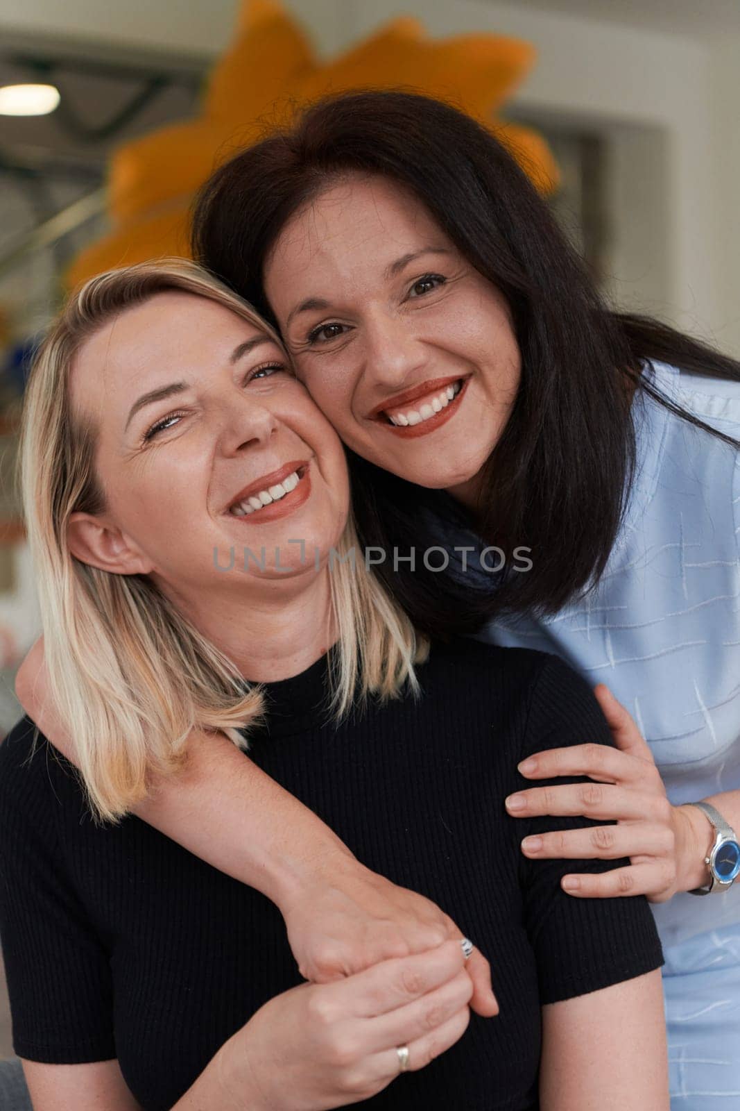 Two women share a heartfelt embrace while at a preschool, showcasing the nurturing and supportive environment for learning and growth by dotshock