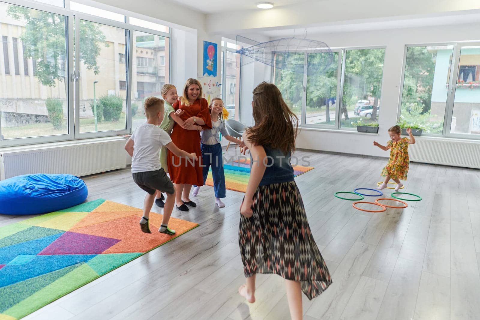 A child hugging a teacher in a modern kindergarten. High quality photo