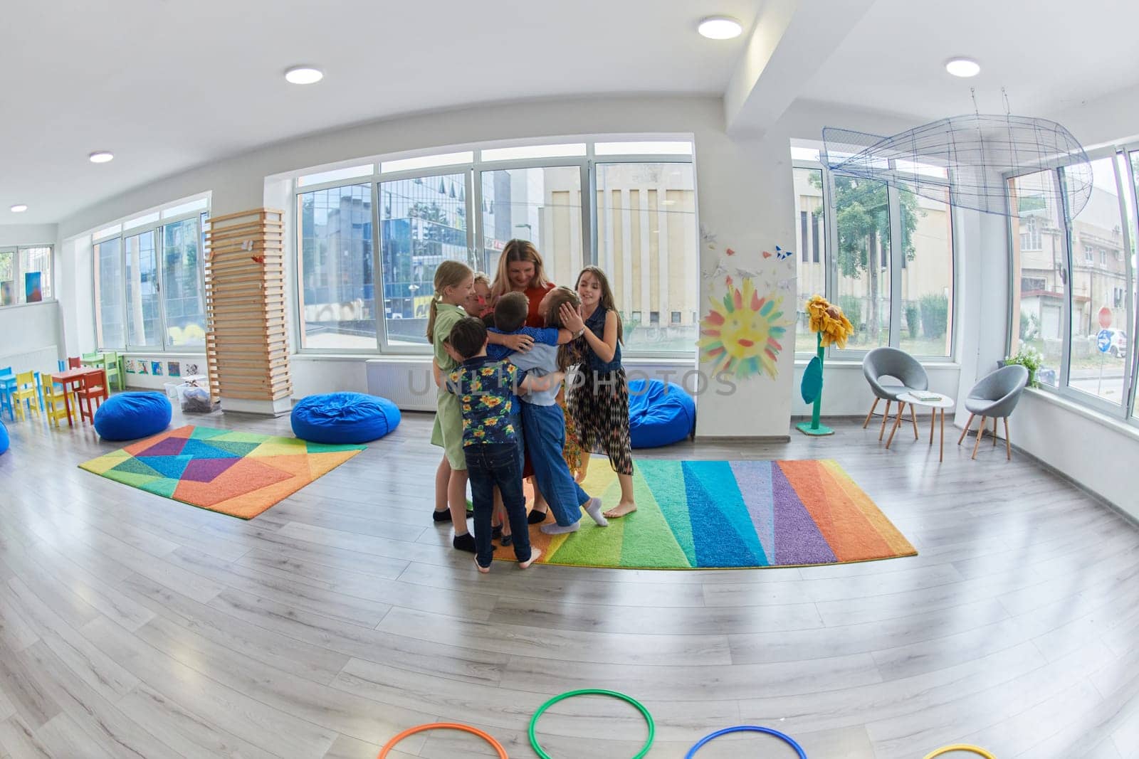 A child hugging a teacher in a modern kindergarten. High quality photo