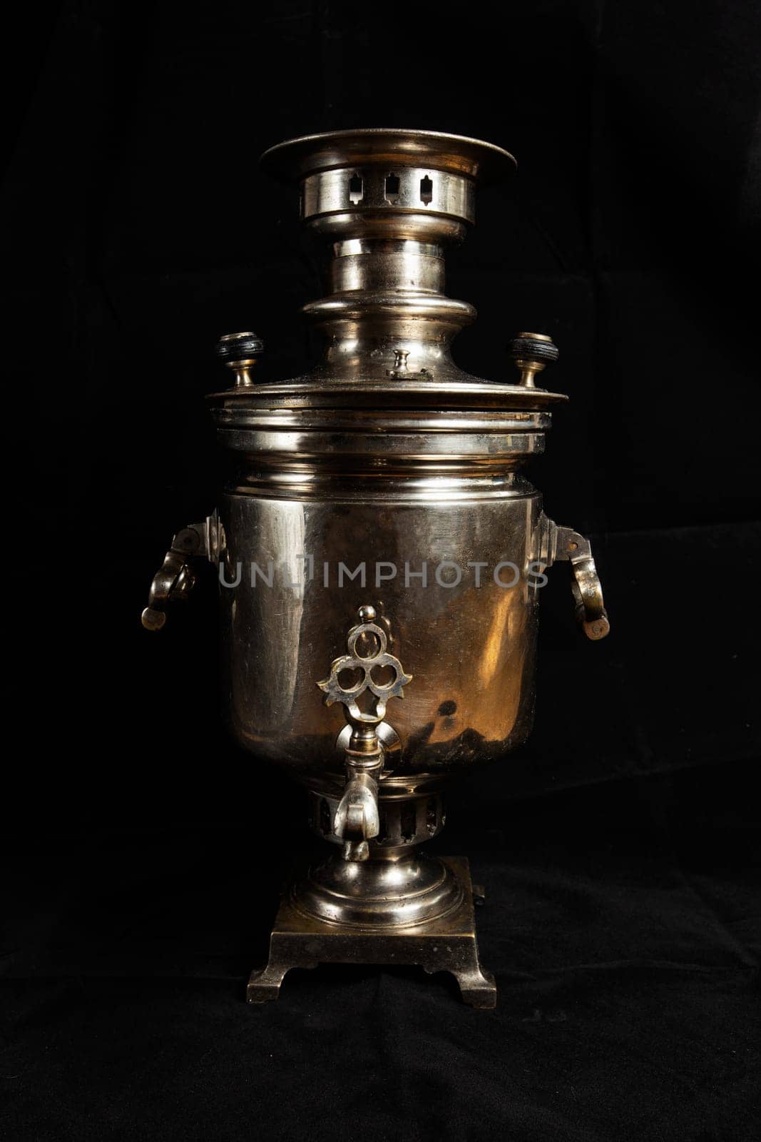 an old samovar isolated on a black background. Metal vessel for boiling water and making tea.Russian samovar