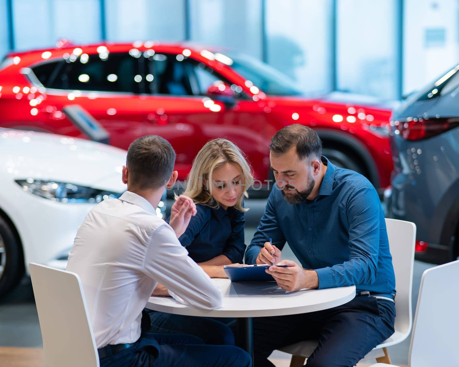 Happy caucasian couple signs a contract for the purchase of a car salon. by mrwed54