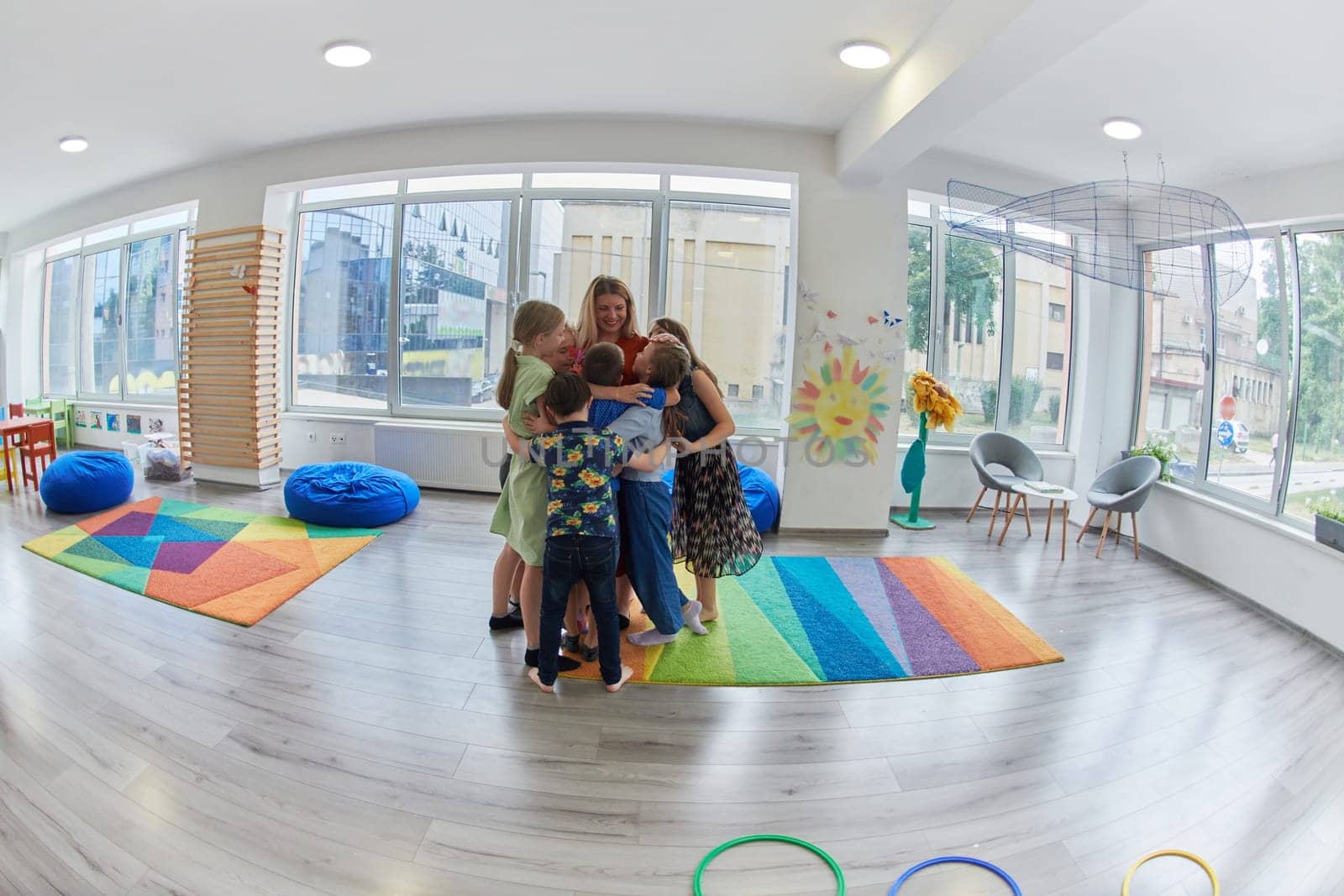 A child hugging a teacher in a modern kindergarten. High quality photo