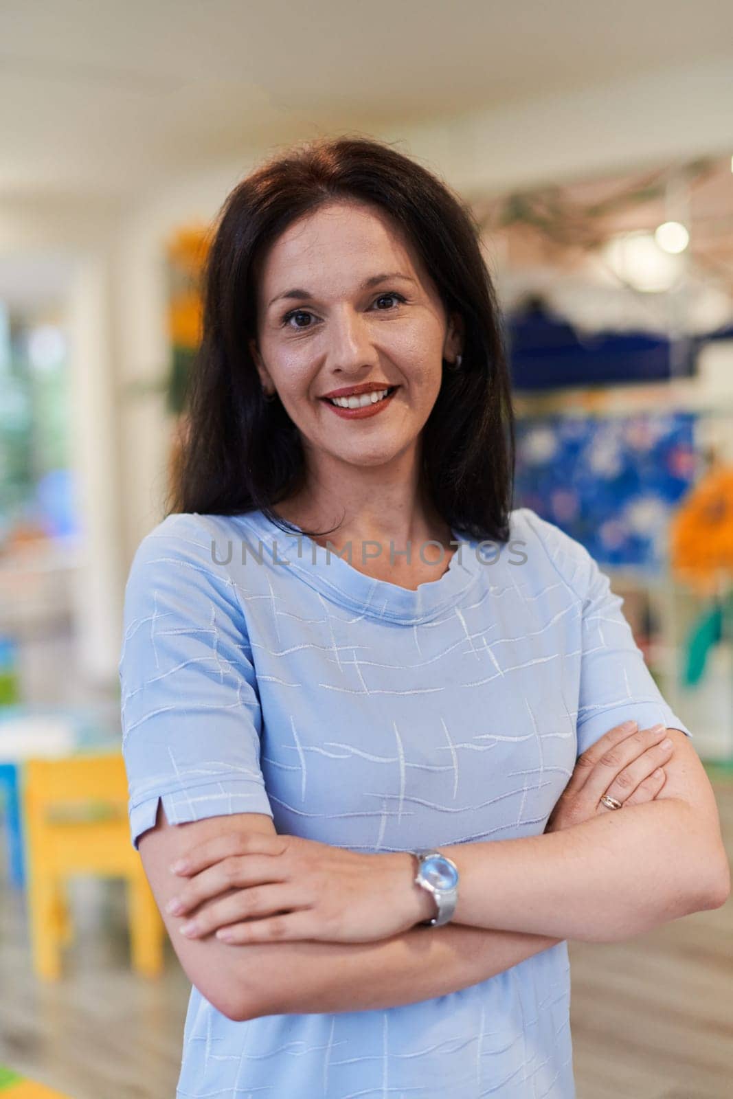 Portrait of a teacher in a preschool institution, in the background of the classrooms. High quality photo