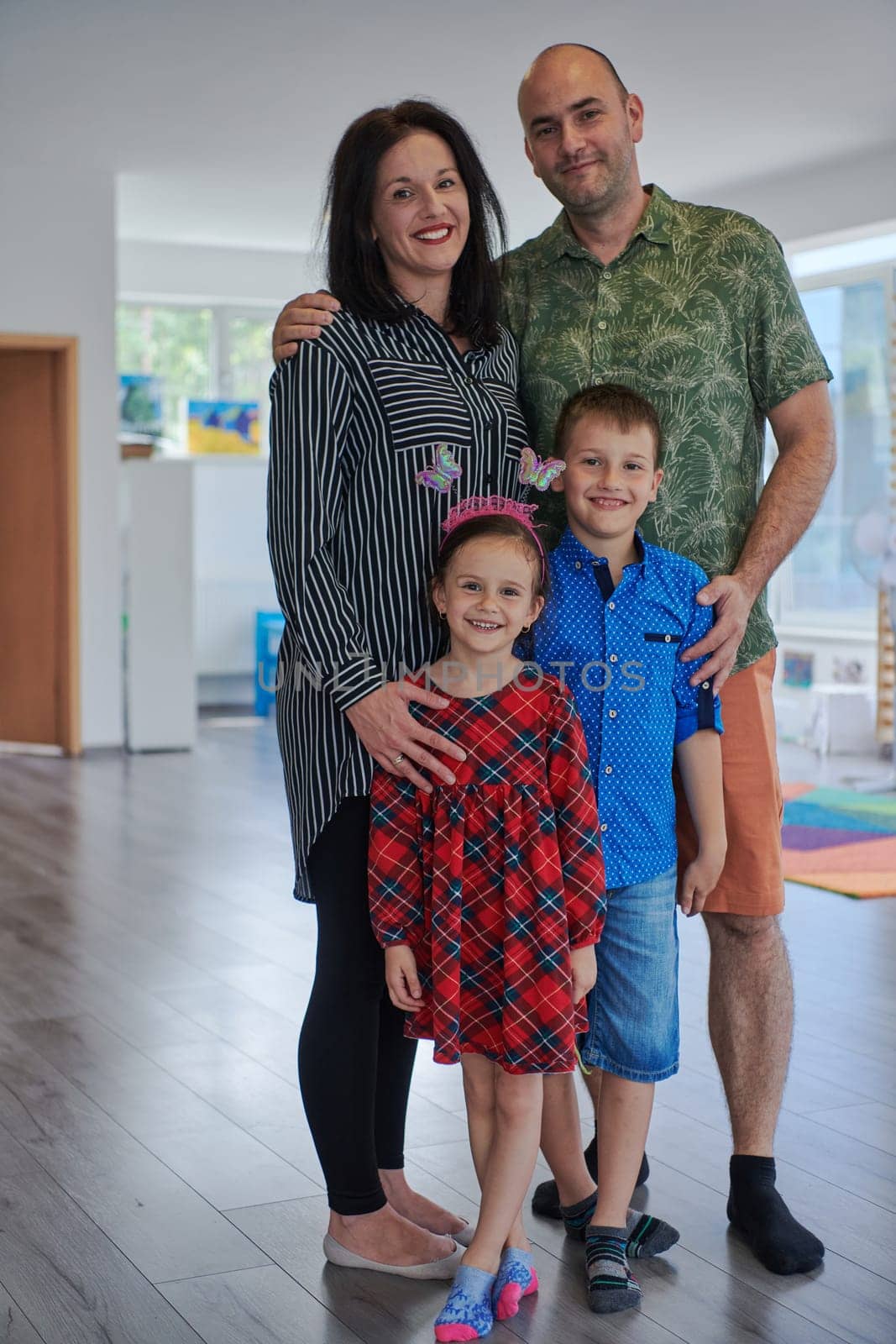 Portrait of a happy family. Photo of parents with children in a modern preschool classroom. Selective focus by dotshock