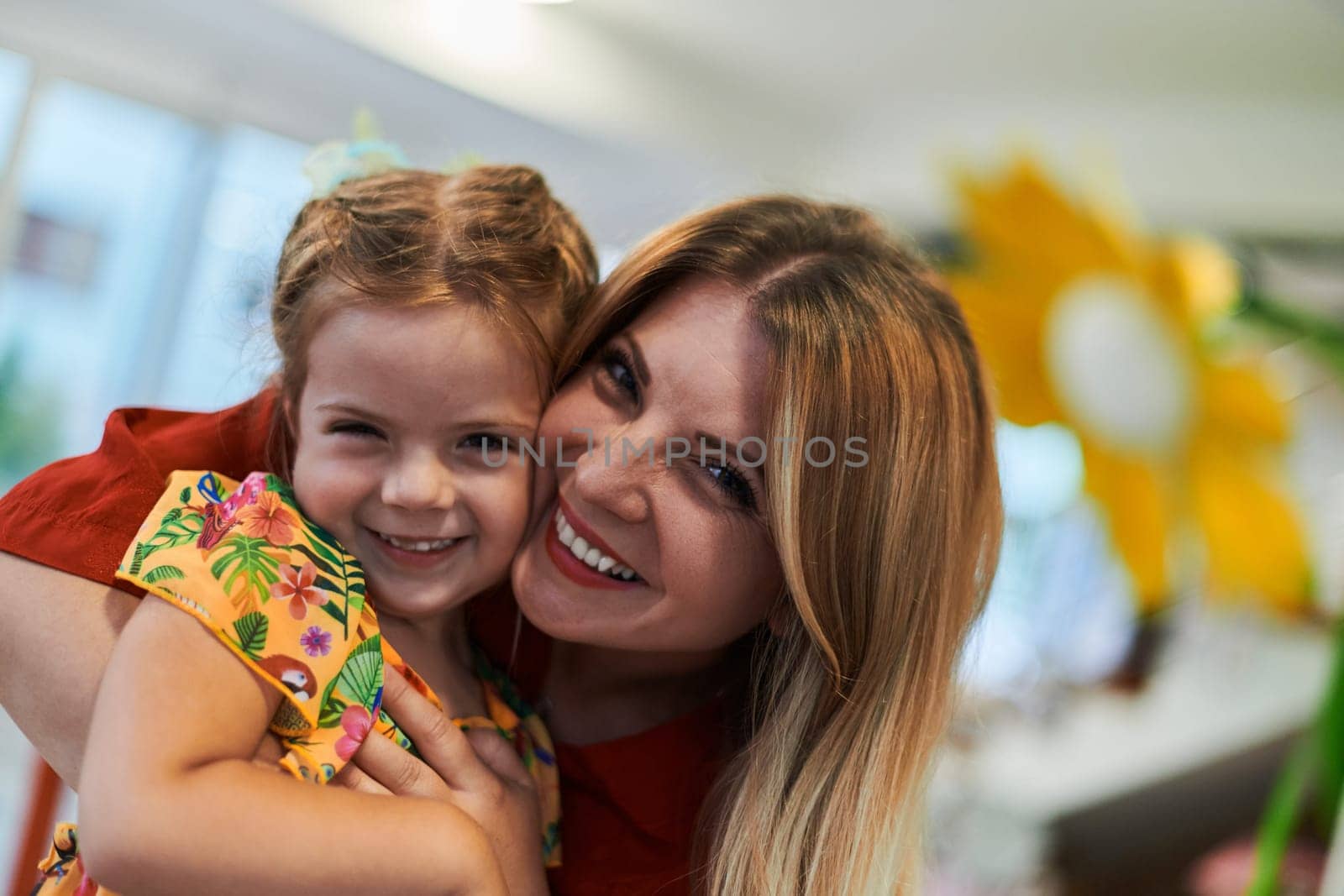 A cute little girl kissing and hugs her mother in preschool. High quality photo