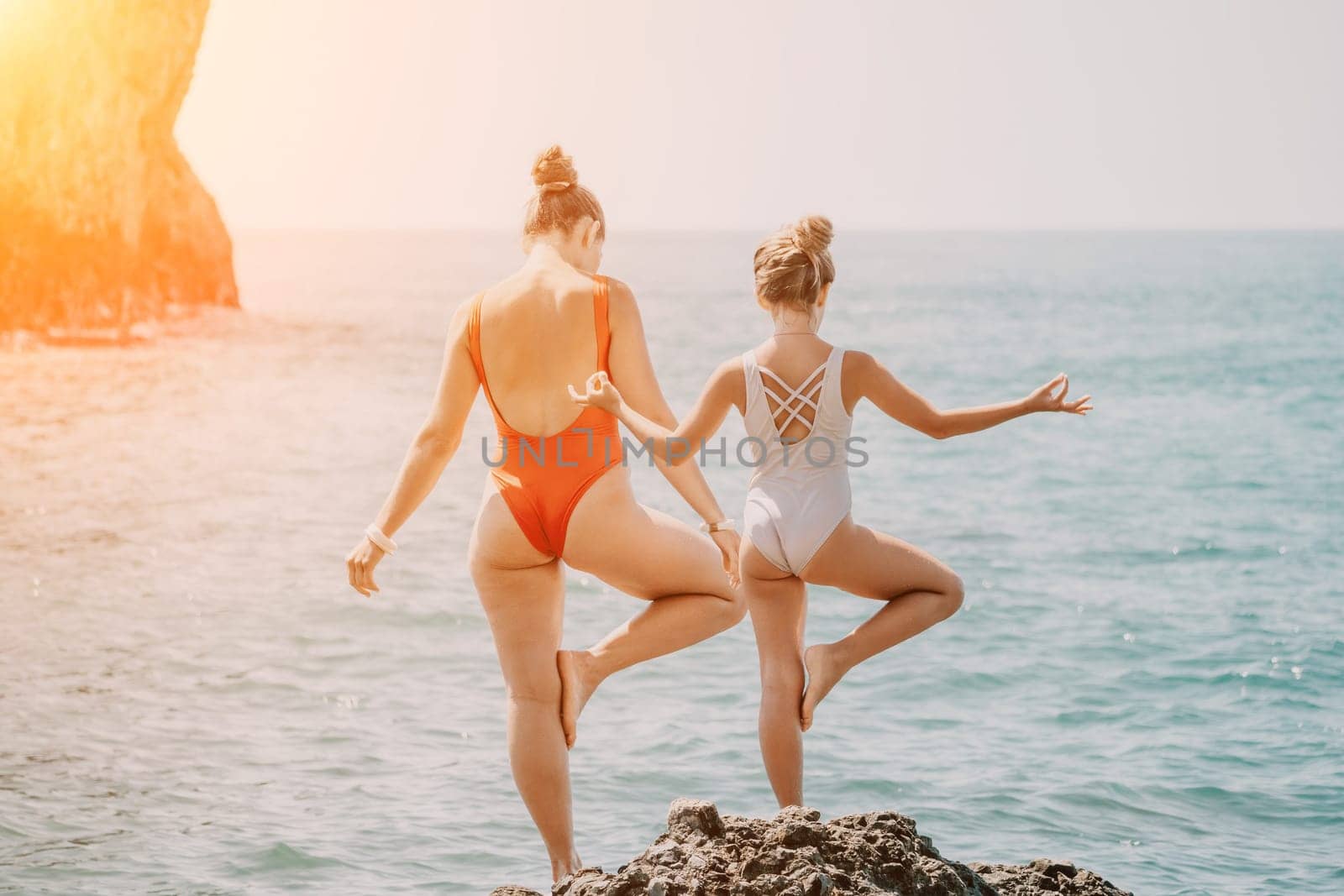 Silhouette mother and daughter doing yoga at beach. Woman on yoga mat in beach meditation, mental health training or mind wellness by ocean, sea