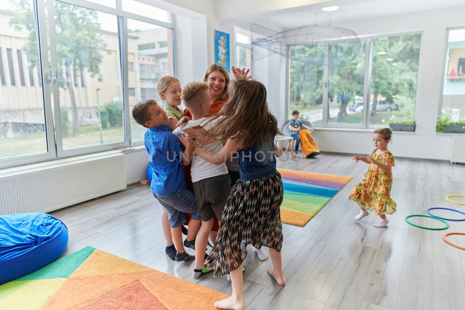 A child hugging a teacher in a modern kindergarten by dotshock