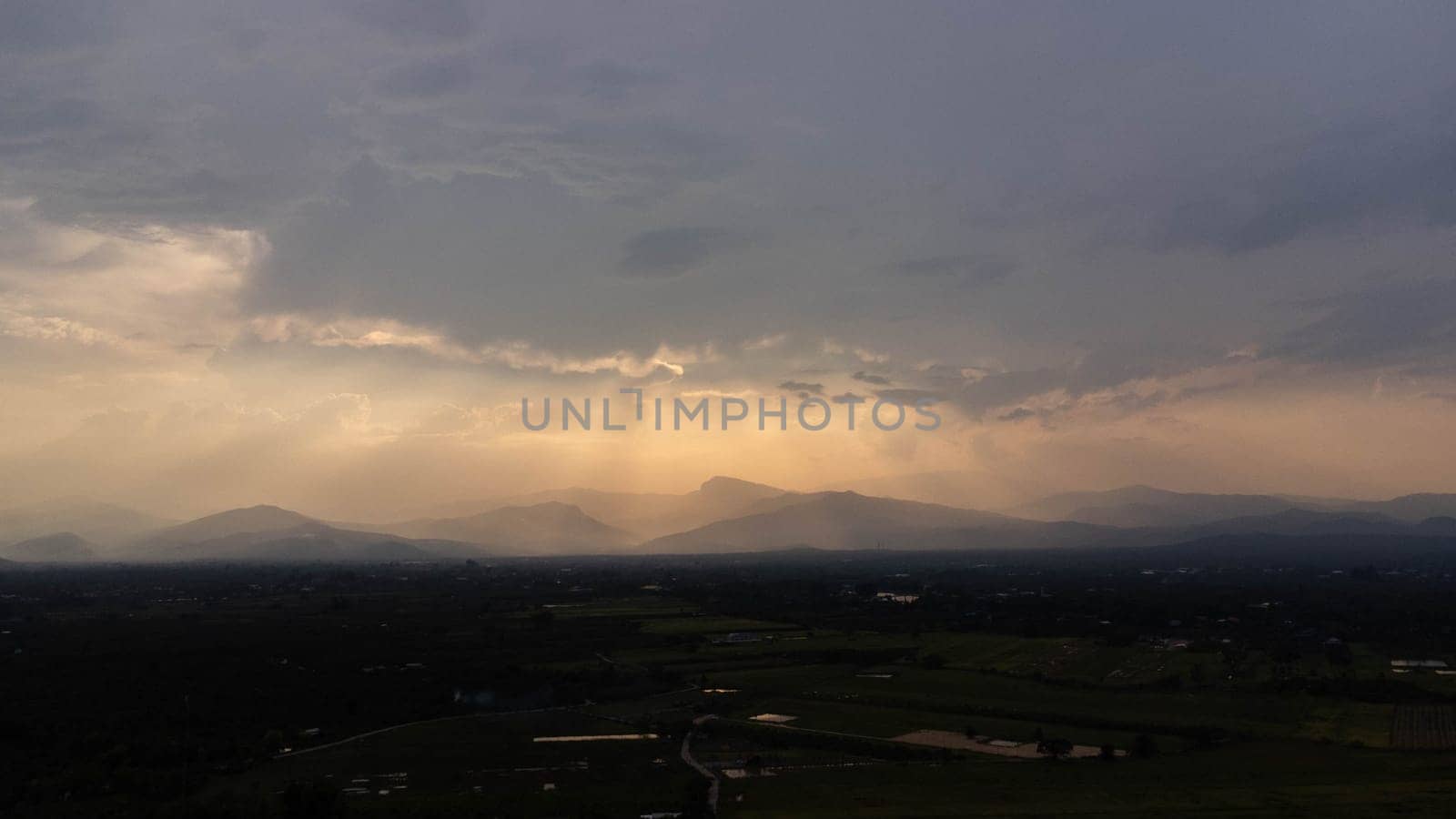 Mountains and beautiful clouds under sunset sky. Beautiful mountain landscape with golden sky. by TEERASAK