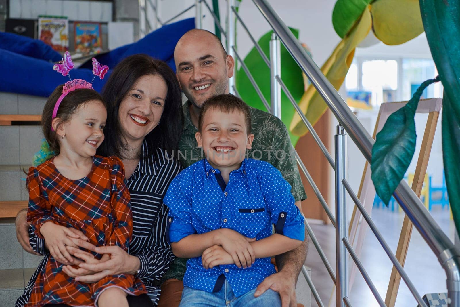 Portrait of a happy family. Photo of parents with children in a modern preschool classroom. Selective focus . High quality photo