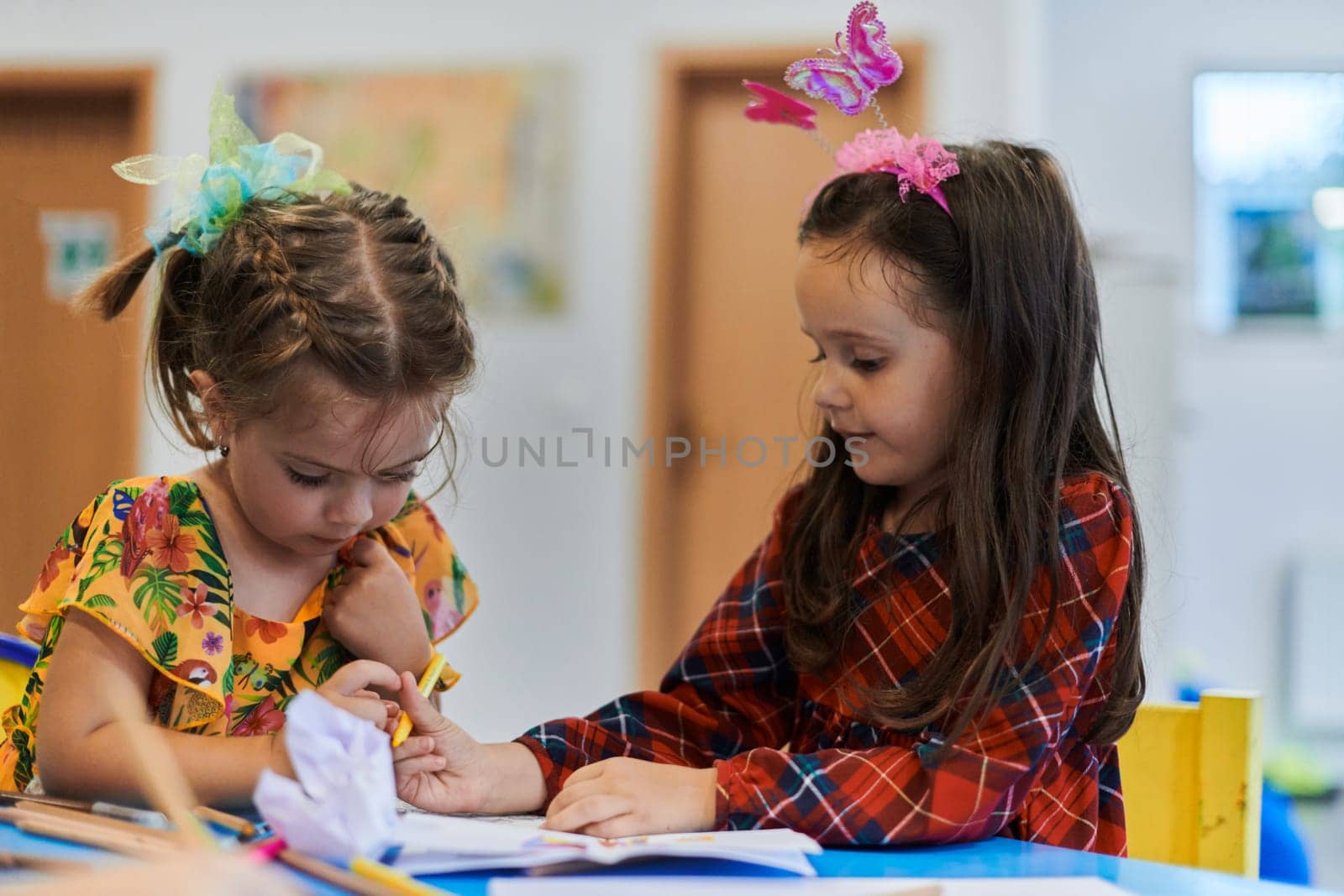 Creative kids sitting in a preschool institution, draw and have fun while they get an education. High quality photo