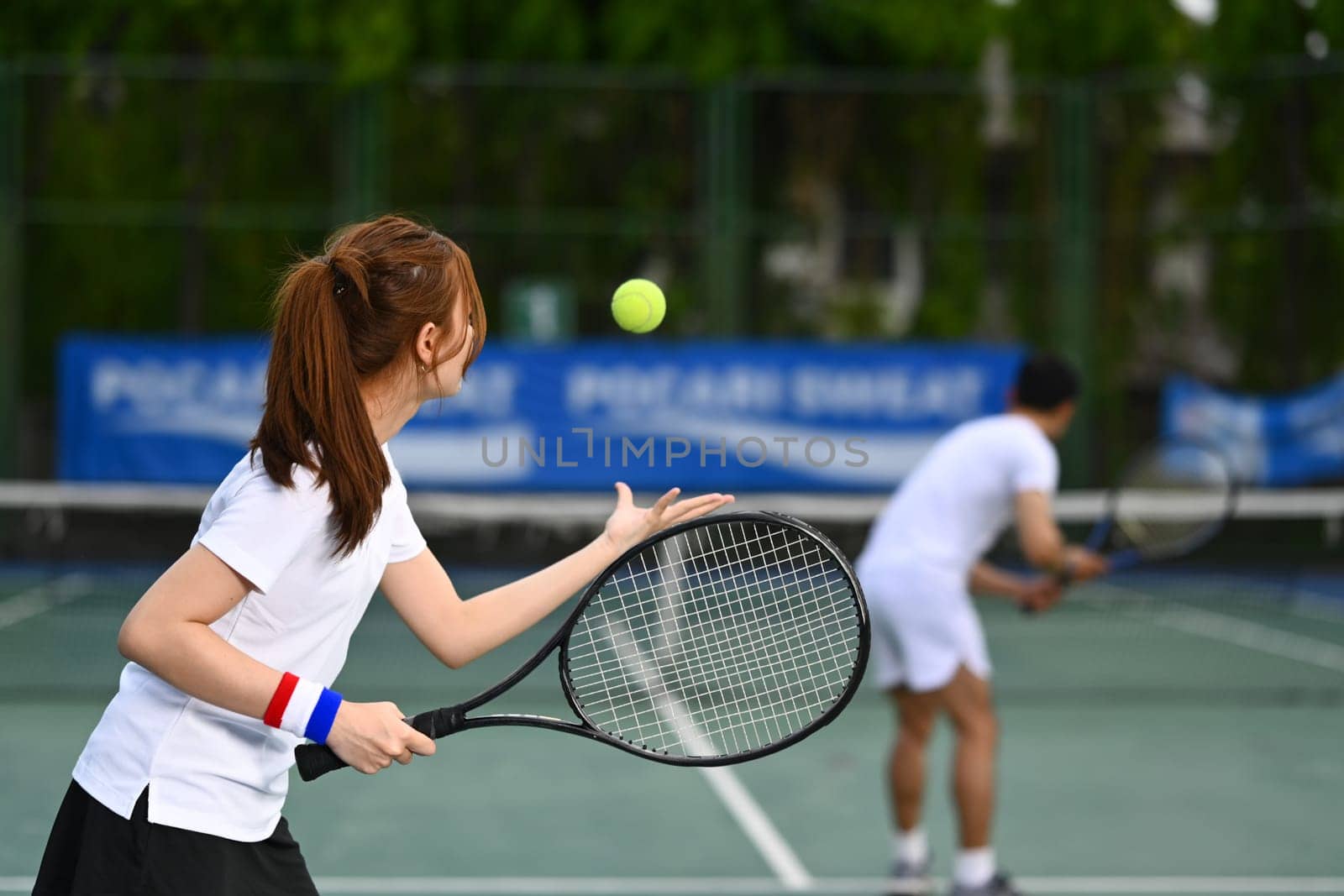 Tennis player serving tennis ball during a match on open court. Sport, fitness, training and active life concept.