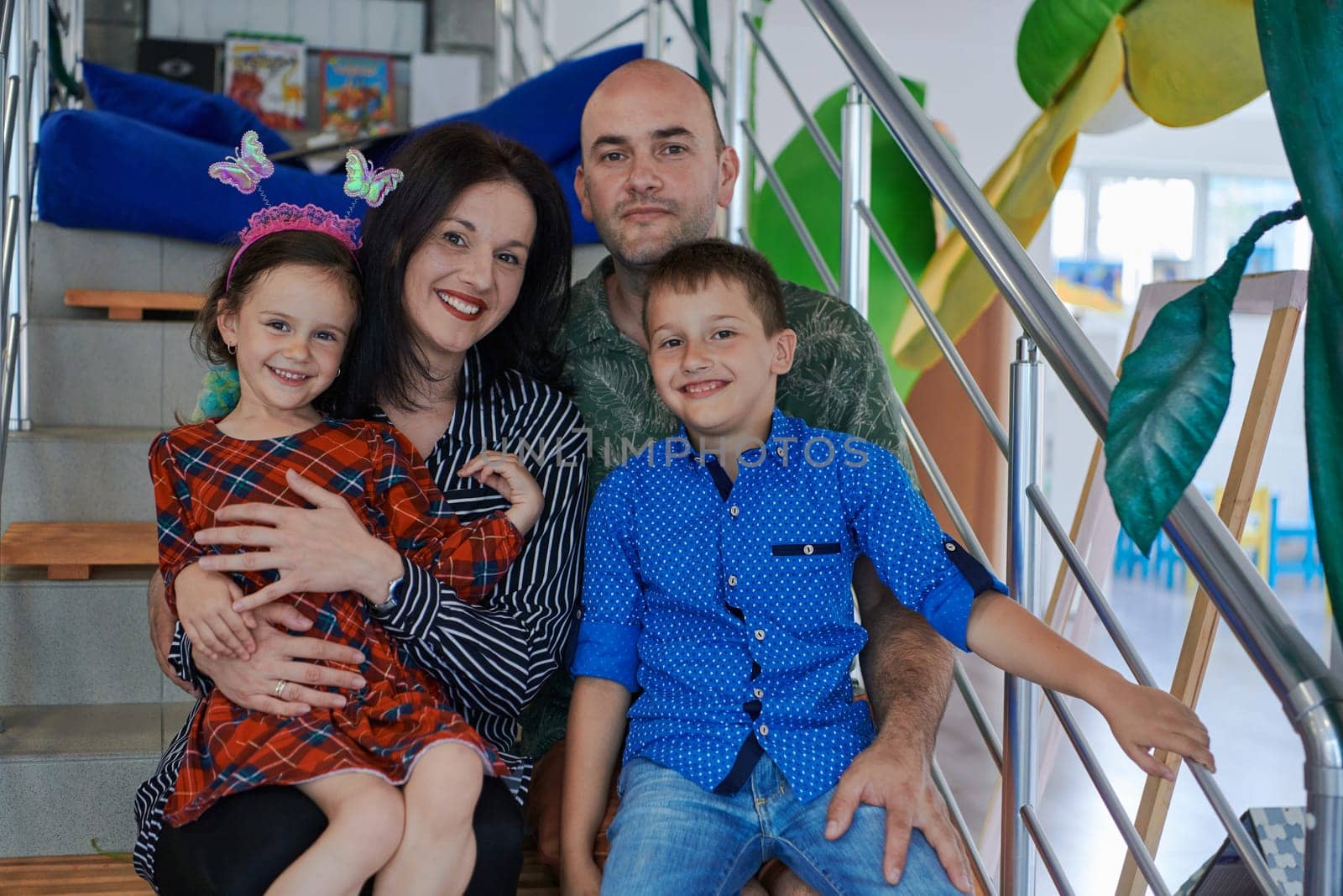 Portrait of a happy family. Photo of parents with children in a modern preschool classroom. Selective focus . High quality photo