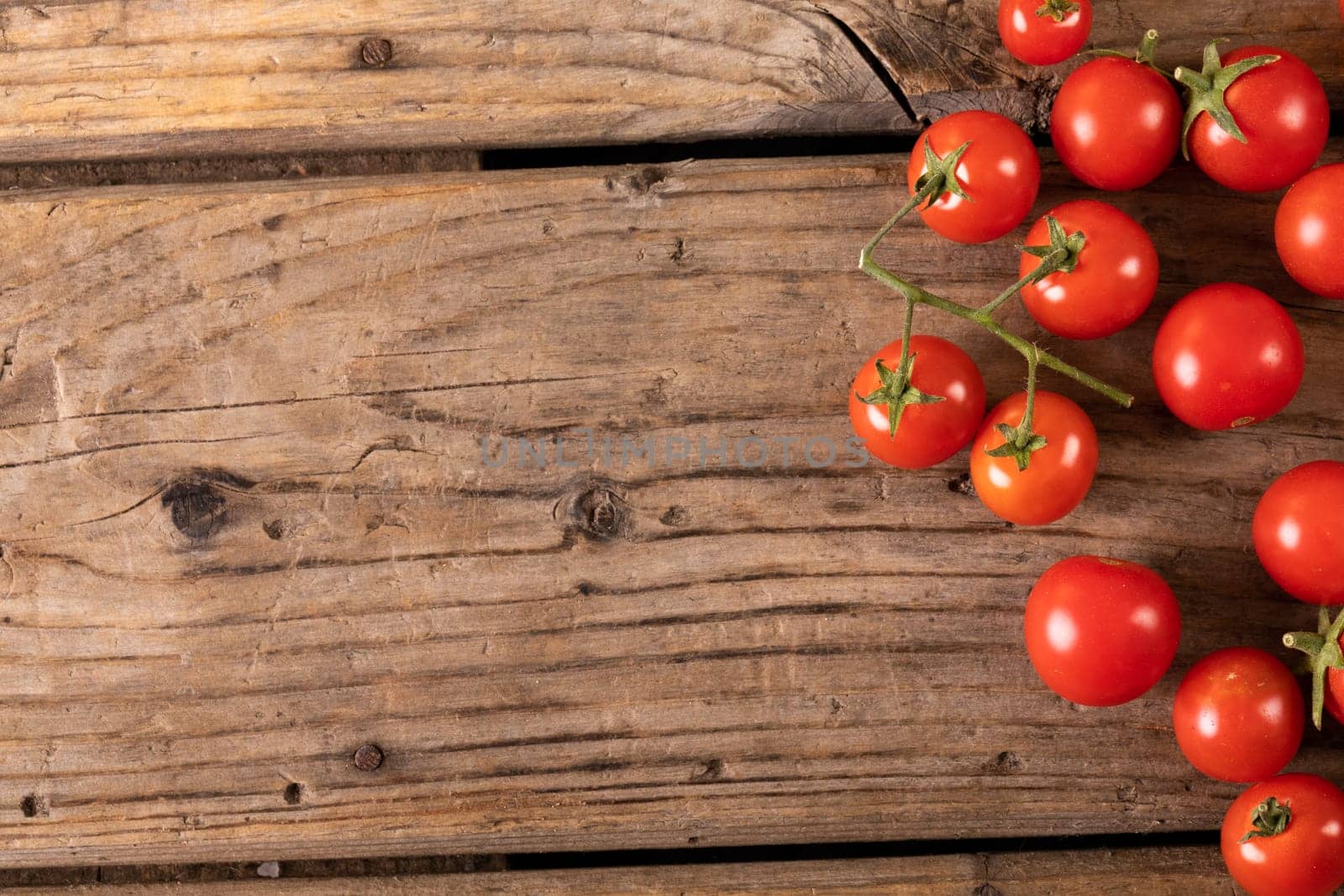 Directly above view of fresh red cherry tomatoes on brown wooden table by Wavebreakmedia