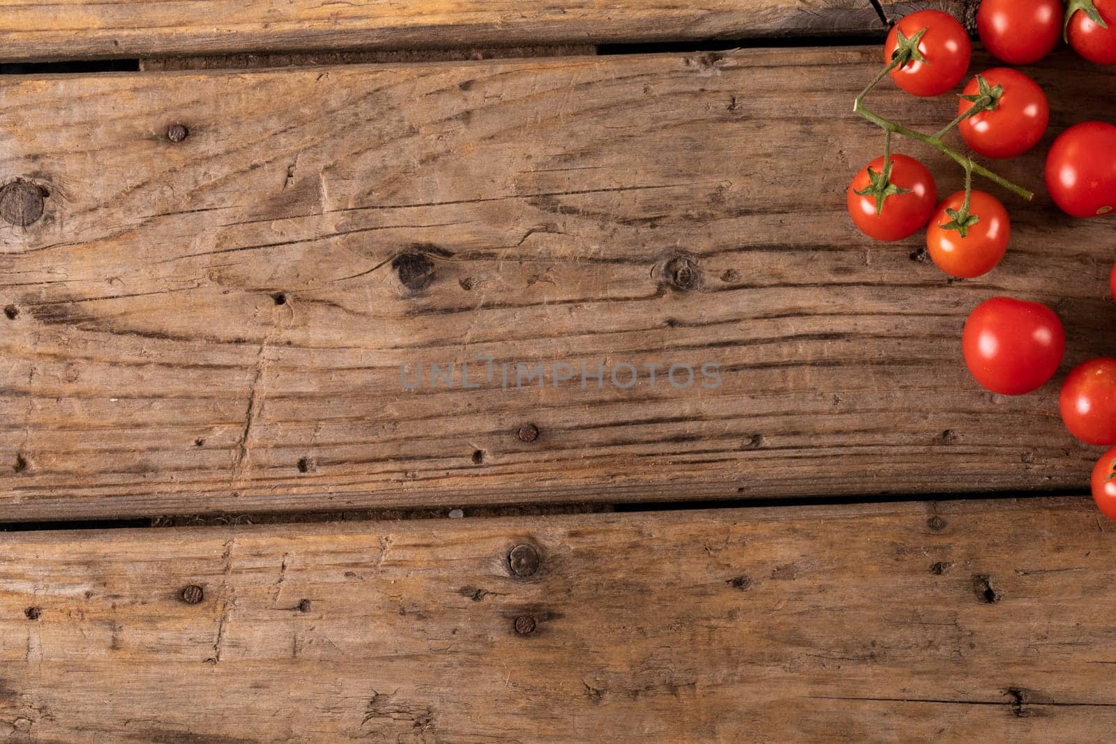 Overhead view of fresh cherry tomatoes on brown wooden table. unaltered, organic food and healthy eating concept.