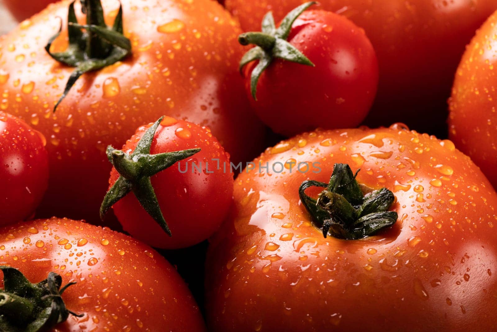 Full frame shot of water drops on fresh red tomatoes. unaltered, organic food and healthy eating concept.