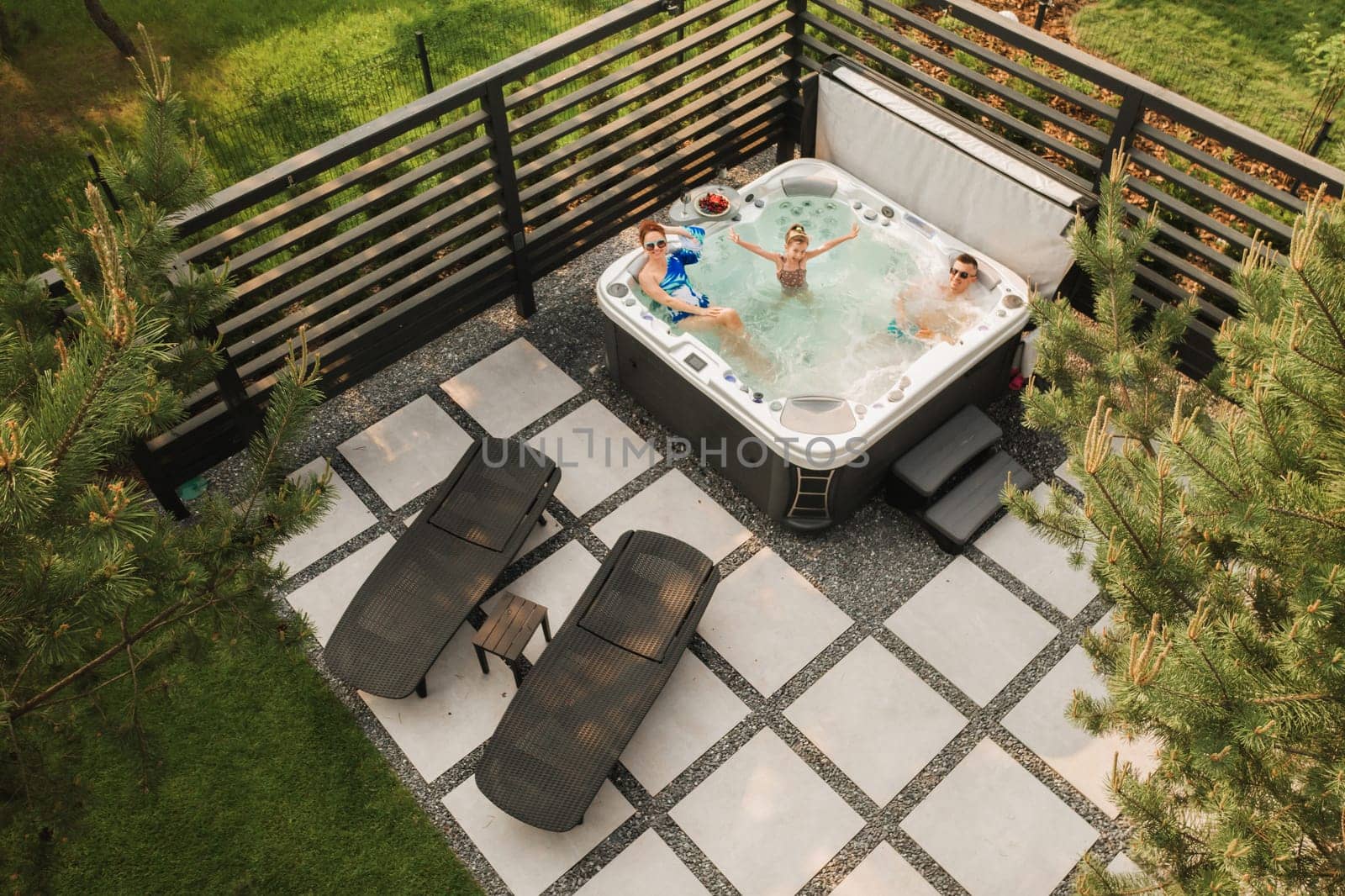 Top view of a family relaxing in an outdoor hot tub in summer.