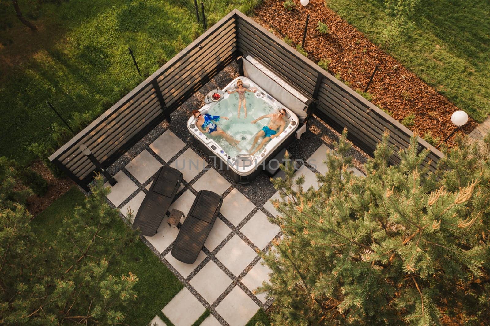 Top view of a family relaxing in an outdoor hot tub in summer.