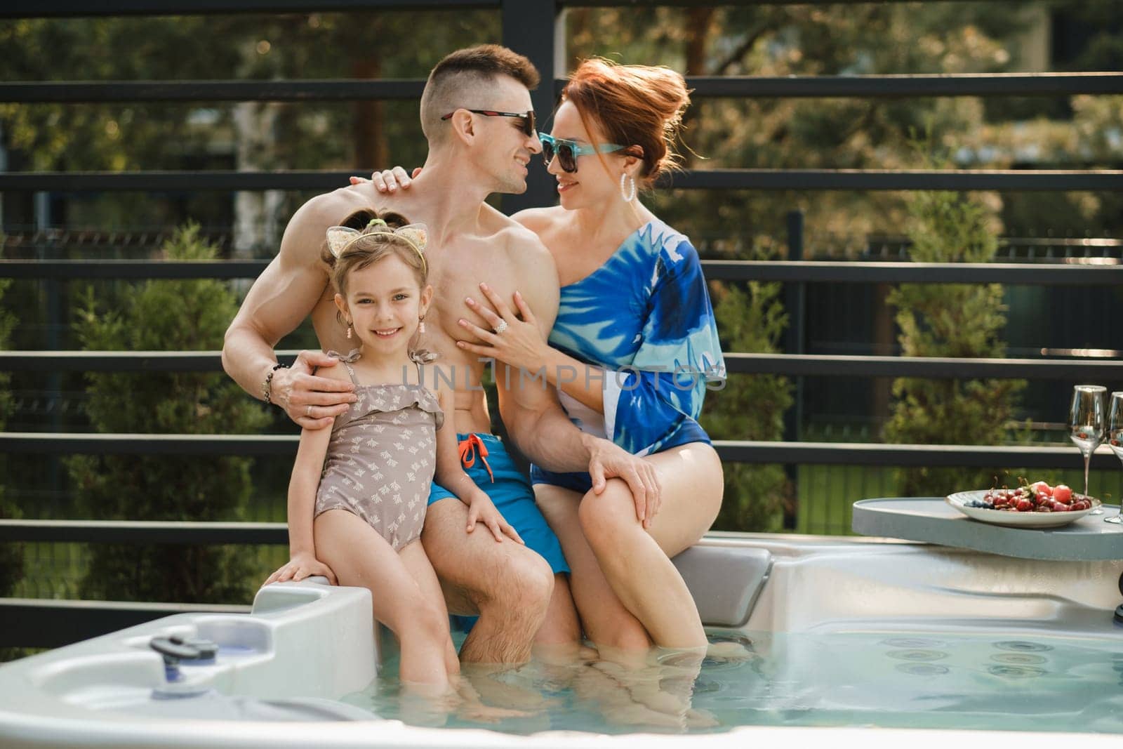 In summer, the family rests in the outdoor hot tub.