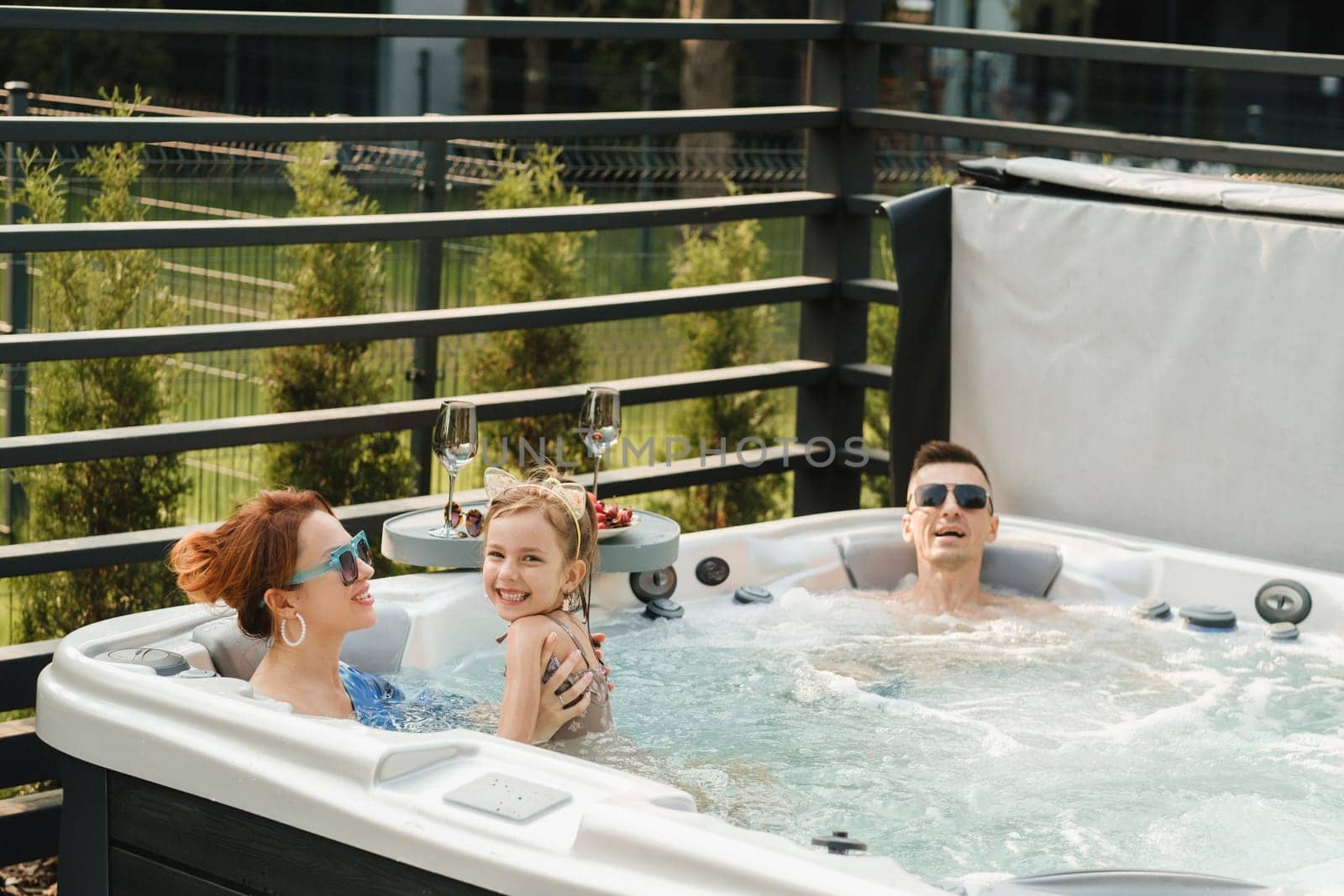 In summer, the family rests in the outdoor hot tub.