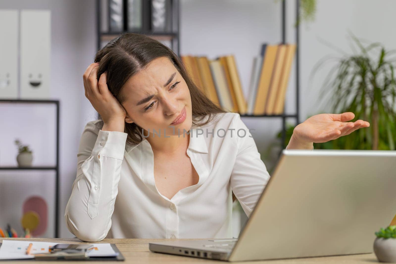Sad caucasian young business woman programmer software developer working on laptop loses becoming surprised by bad news results fortune loss fail at office. Deadline, bankruptcy. Freelancer girl
