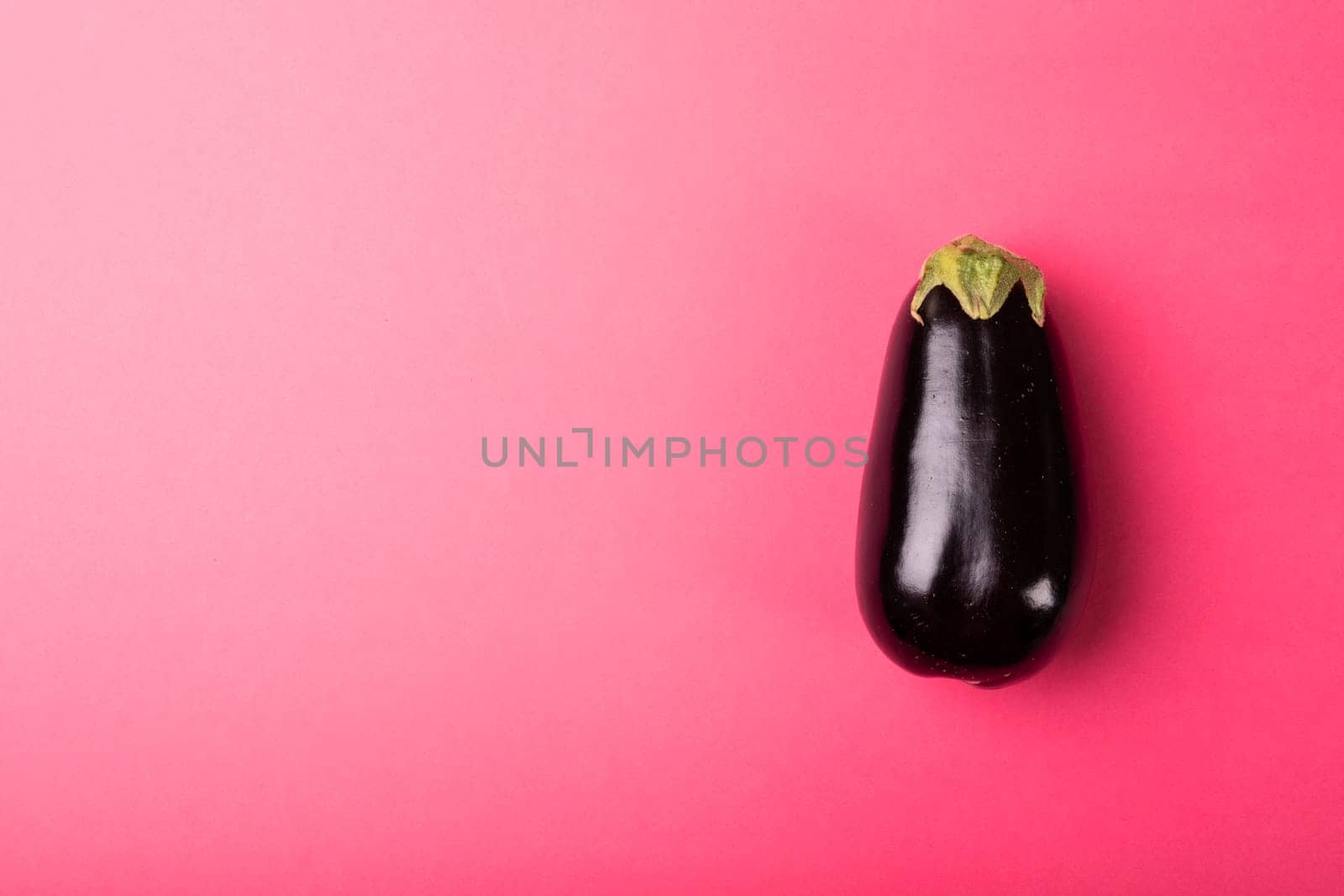 Overhead view of fresh eggplant by copy space against pink background by Wavebreakmedia