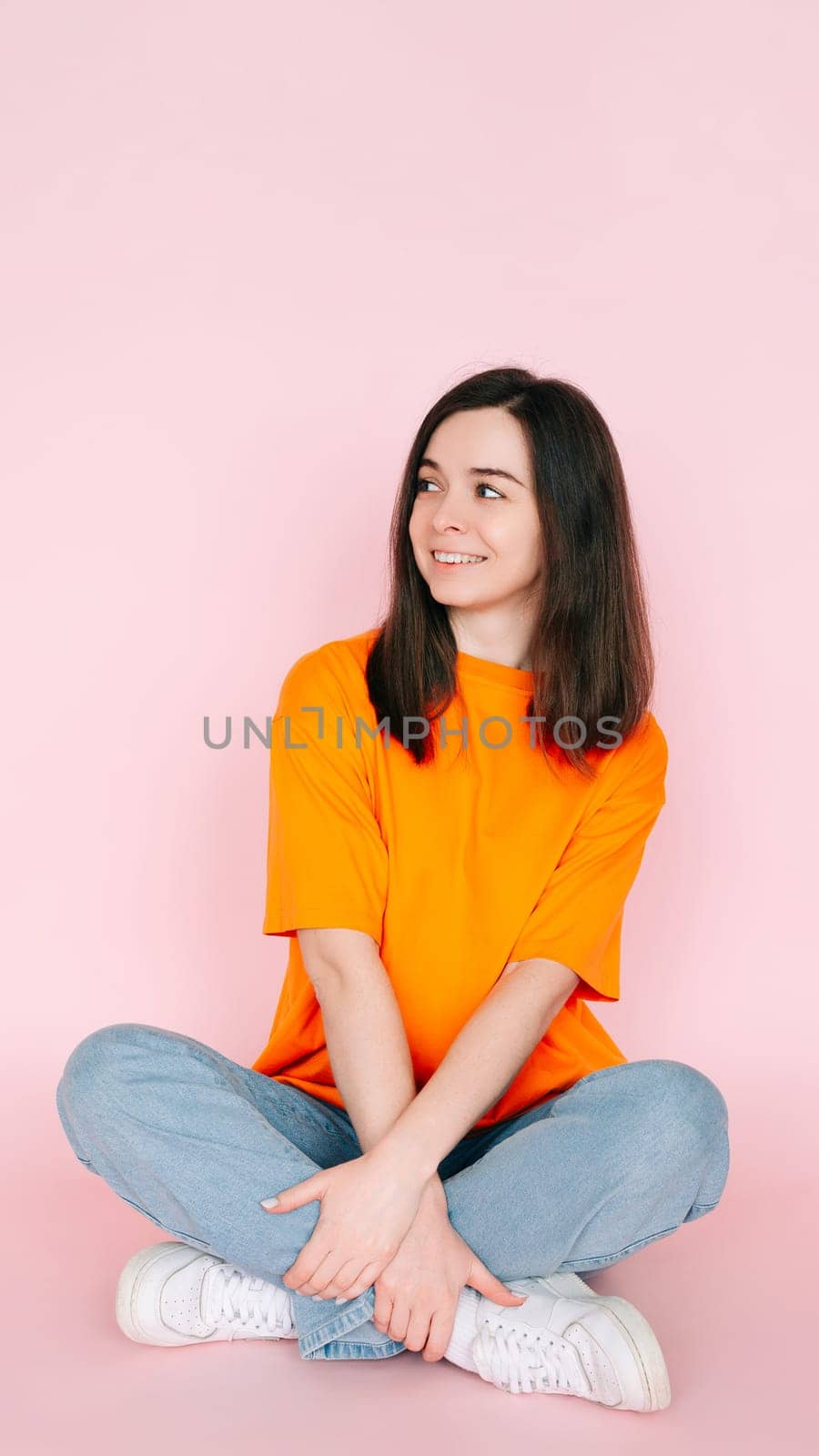 Dreaming in Serenity: Beautiful Woman Seated Comfortably in Lotus Position, Gazing into Empty Space, Yearning for a New Love - Tranquil Mood on Pink Background.