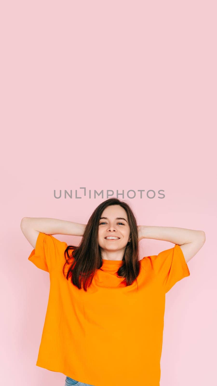 Summer Daydreams: Cheerful Woman in Comfortable Attire, Hands Behind Head, Imagining the Bliss of Summer - Optimism and Anticipation Concept, Isolated on Pink Background