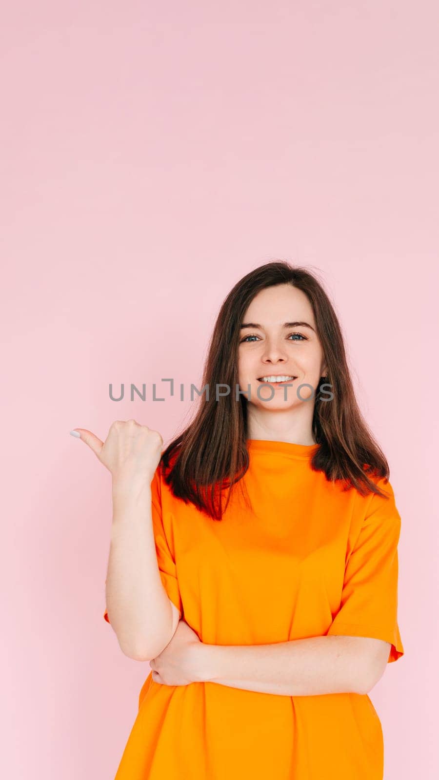 Positive Affirmation: Lovely Woman Pointing Thumb at Empty Space - Encouraging Positivity and Possibilities, Isolated on Pink Background