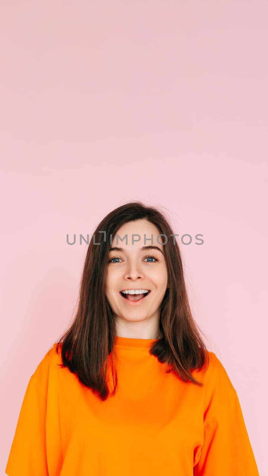 Surprised Delight: Cheerful Woman Expressing Amazement with Open Mouth - Joyful Reaction and Positive Energy on Vibrant Pink Background