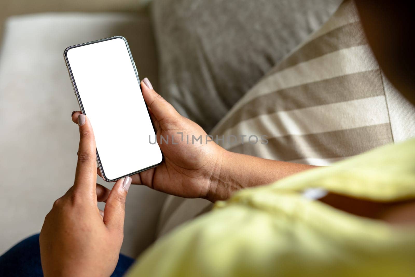 Close-up midsection of african american mid adult woman using smart phone with blank screen. unaltered, copy space, wireless technology, lifestyle and domestic life concept.