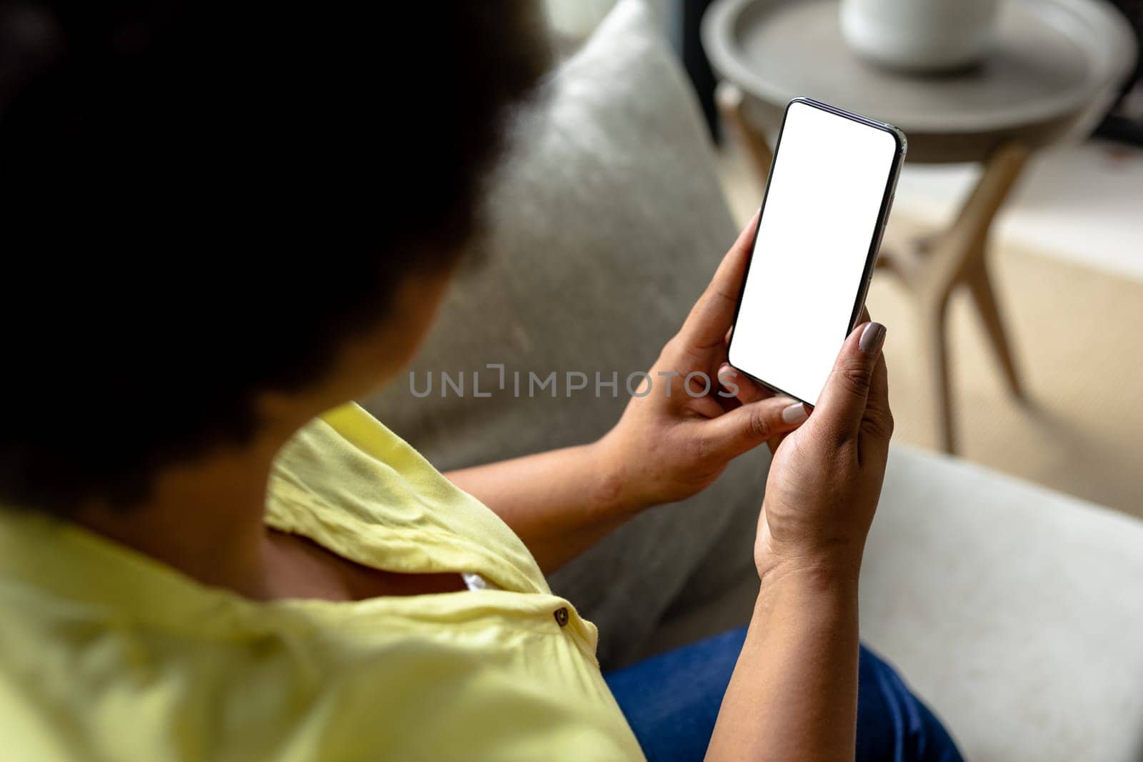 Close-up african american mid adult woman using smart phone with blank screen during video call by Wavebreakmedia