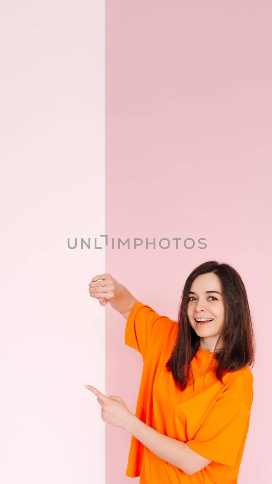 Affordable Deals: Optimistic Girl Holding Paper Board with Empty Space - Presentation of Cheap Prices for Advertising, Isolated on Pink Background