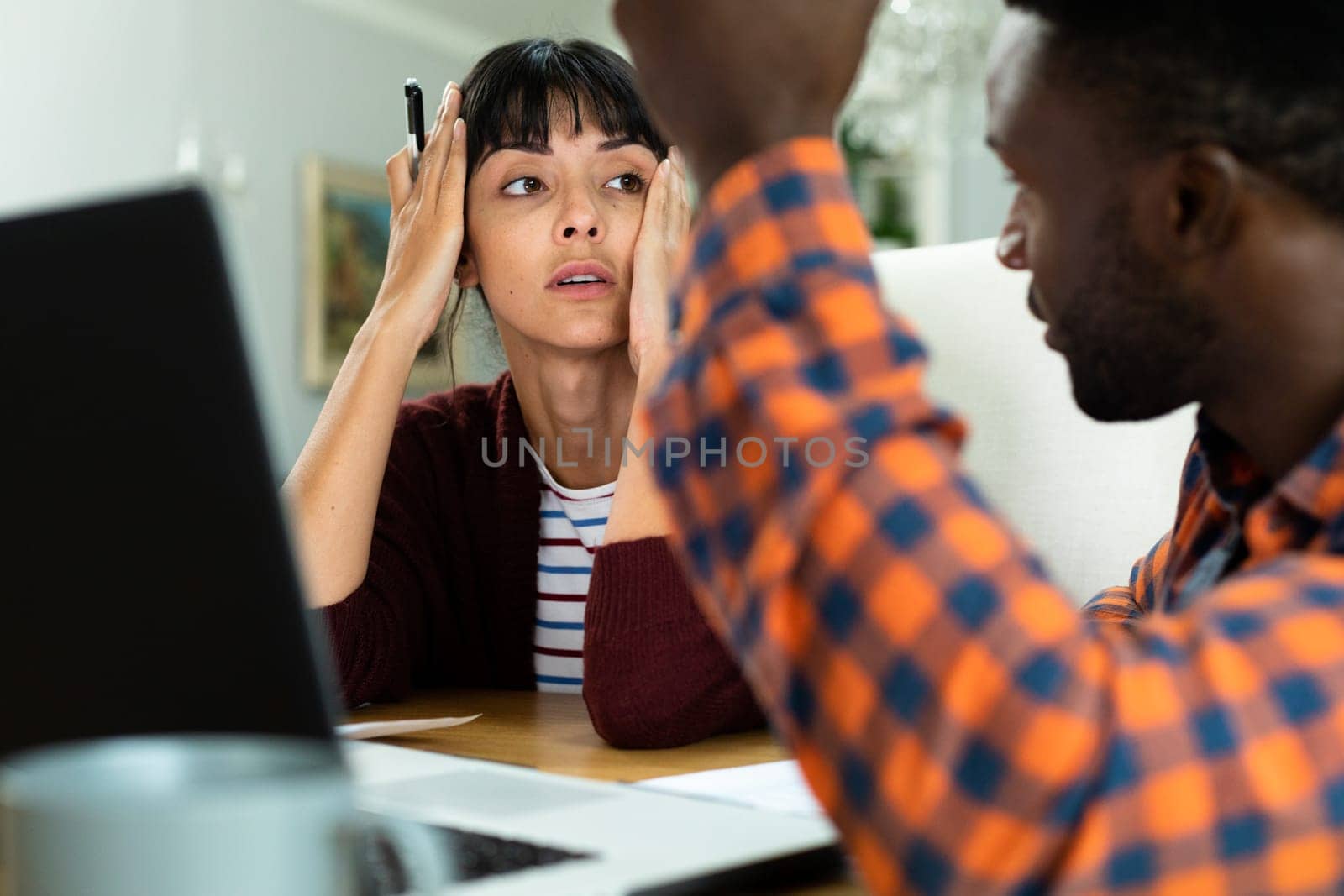 Tensed multiracial young couple discussing household budget at home. unaltered, lifestyle, stress, finance, planning, calculating, expenses, problems, savings.